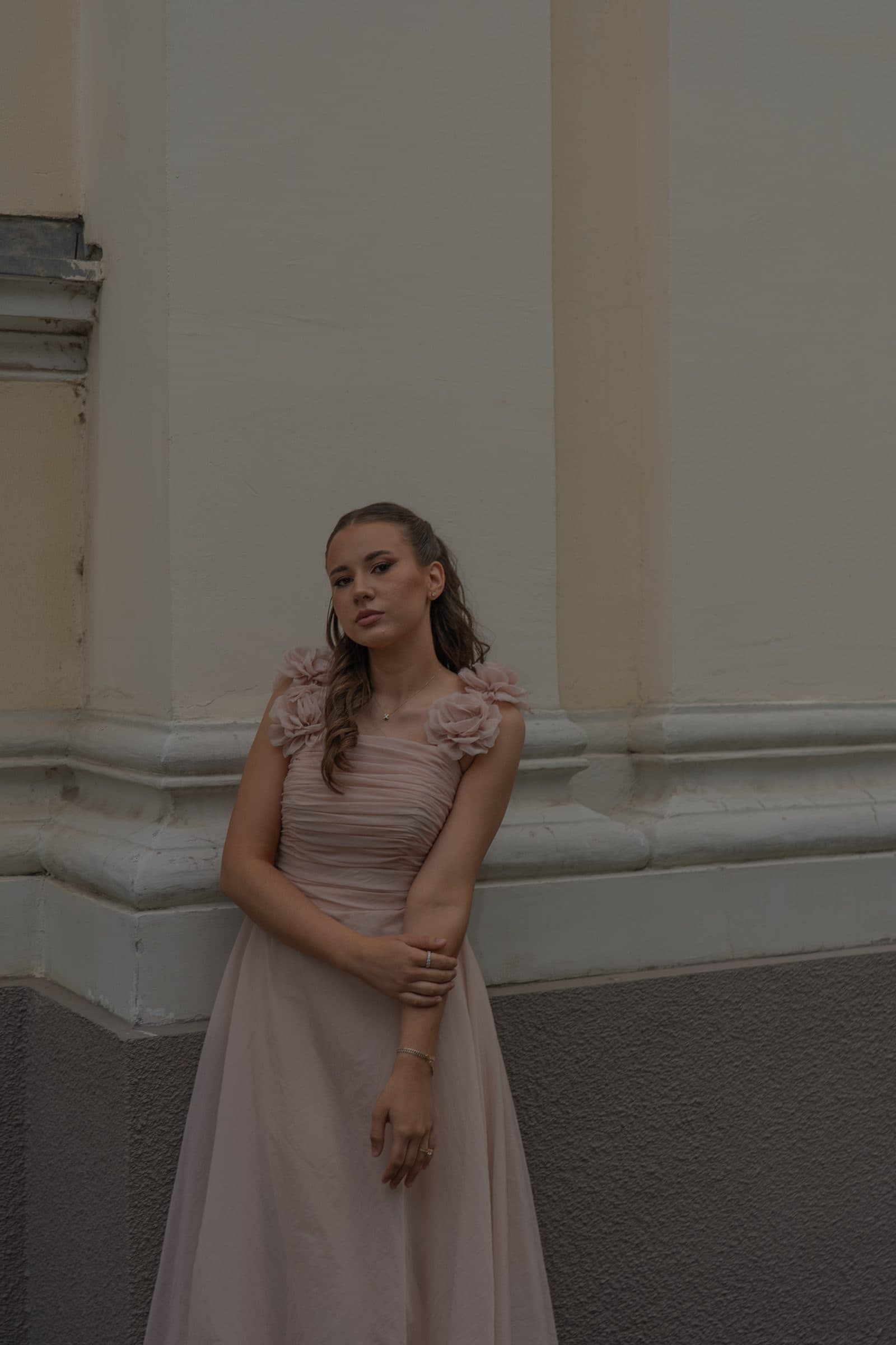 Sumeja leaning against a wall, looking into the camera