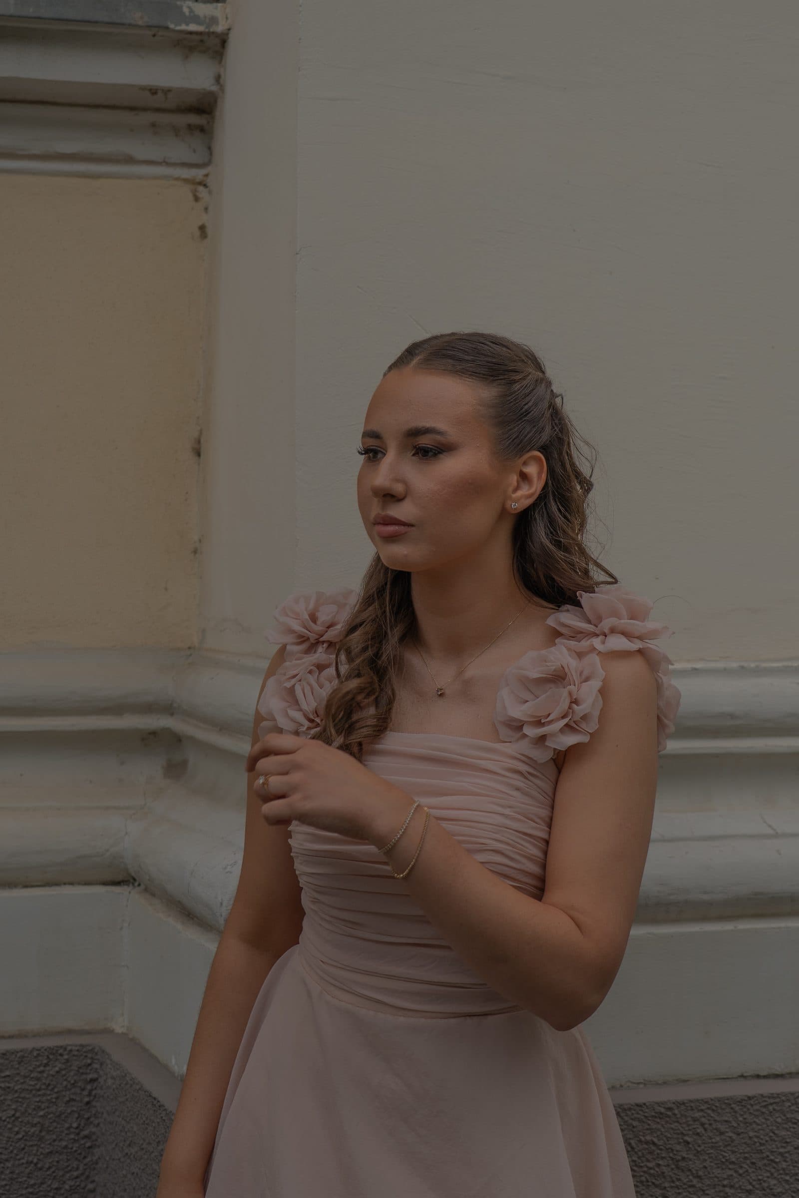 Sumeja looking away by a pale wall